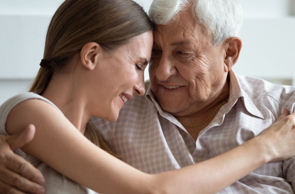 A loving young woman comforting her older adult father.