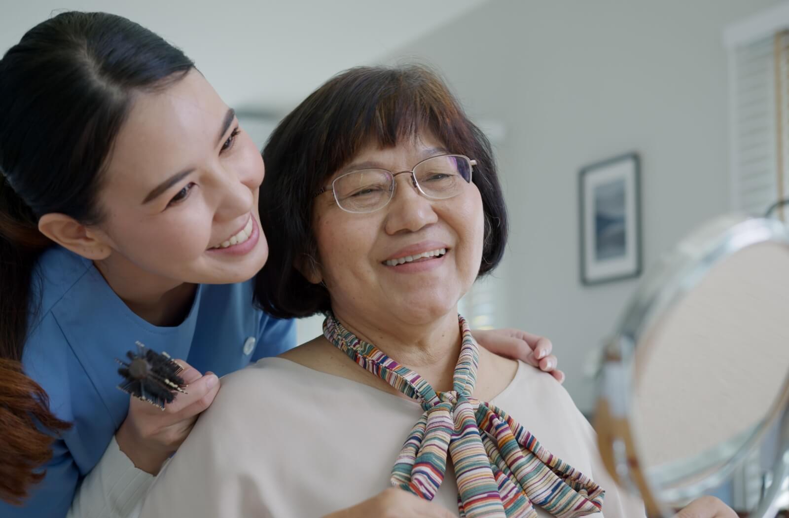 A memory care community staff member helps a senior with getting ready for the day as part of their routine