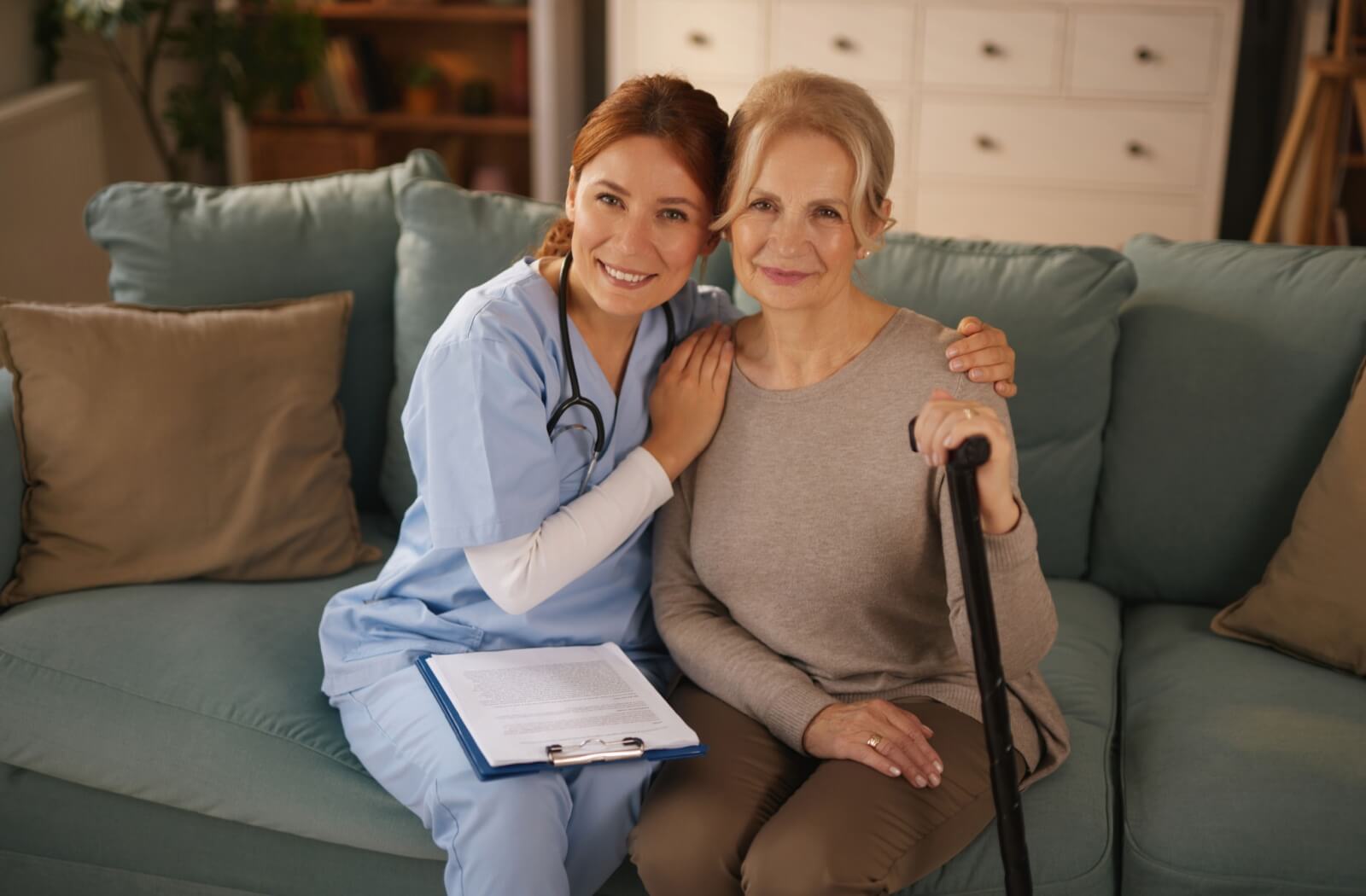 A nurse smiles with a senior holding a cane, helping with rehabilitation in respite care after an injury